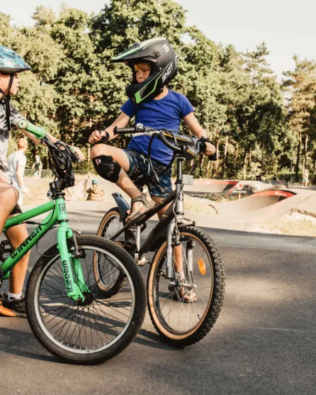 Camping de kleine wolf faciliteit pumptrack jongens op fiets kijken elkaar